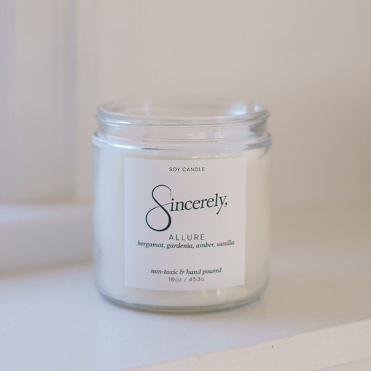 Candle jar labeled 'Sincerely' on a white surface with a light background