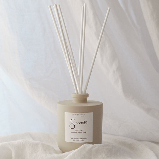 Scented diffuser with reeds on a light fabric background