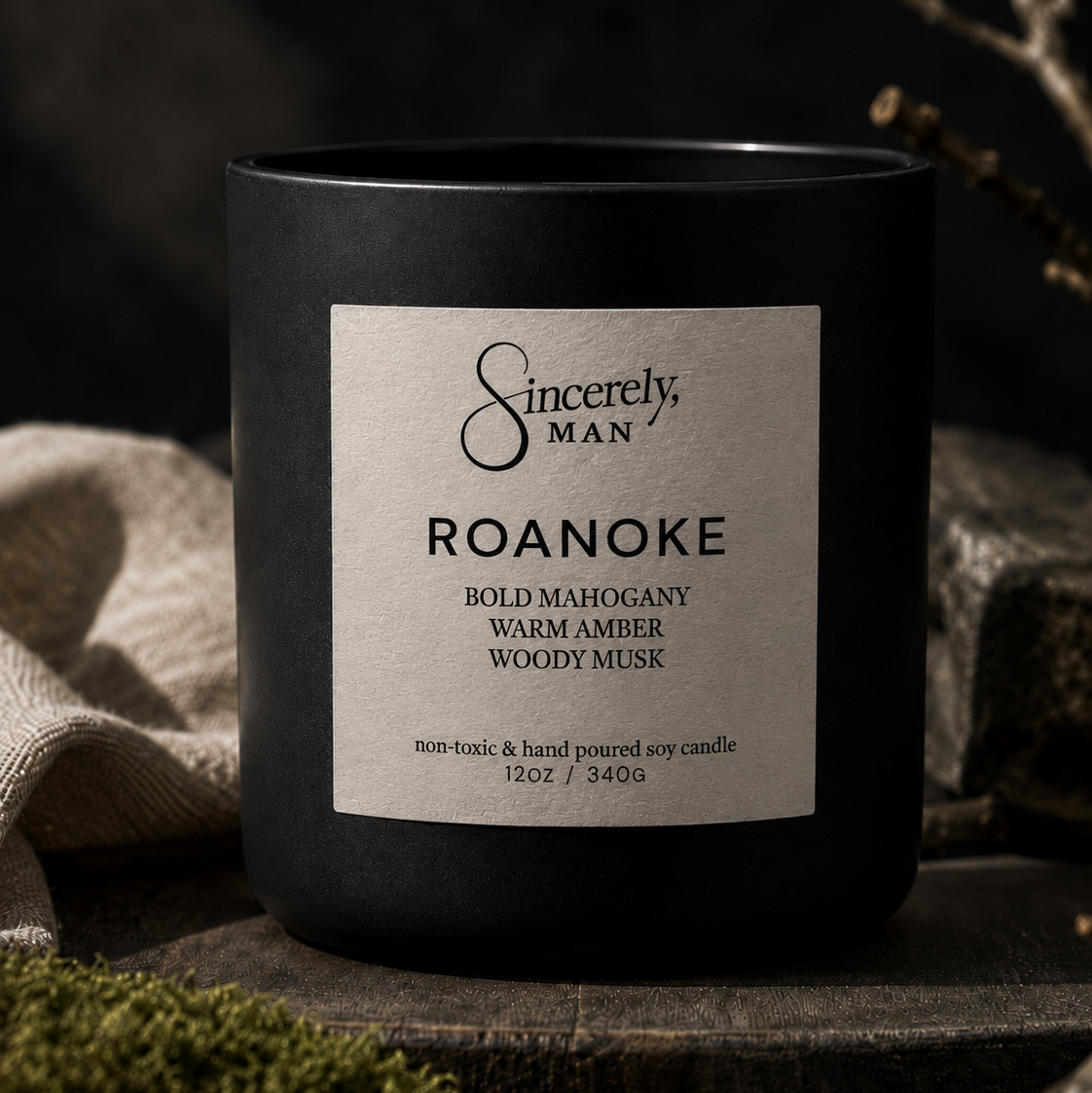 Black candle with 'Sincerely, Man' label on a dark background