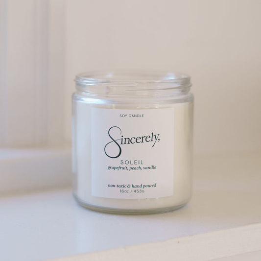 Candle jar labeled 'Sincerely' on a white surface with a white background