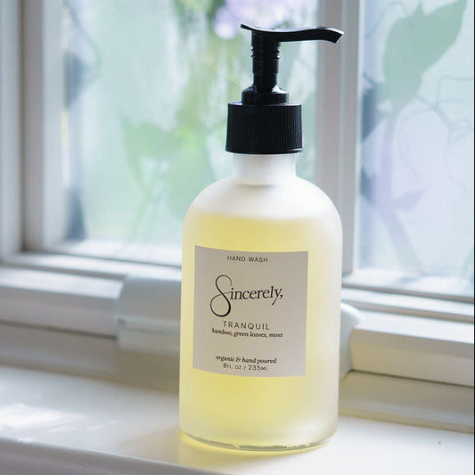 Hand soap bottle labeled 'Sincerely' on a windowsill with natural light