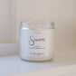 Candle jar labeled 'Sincerely' on a white surface with a white background