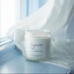Candle labeled 'Sincerely' on a windowsill with light blue curtains.