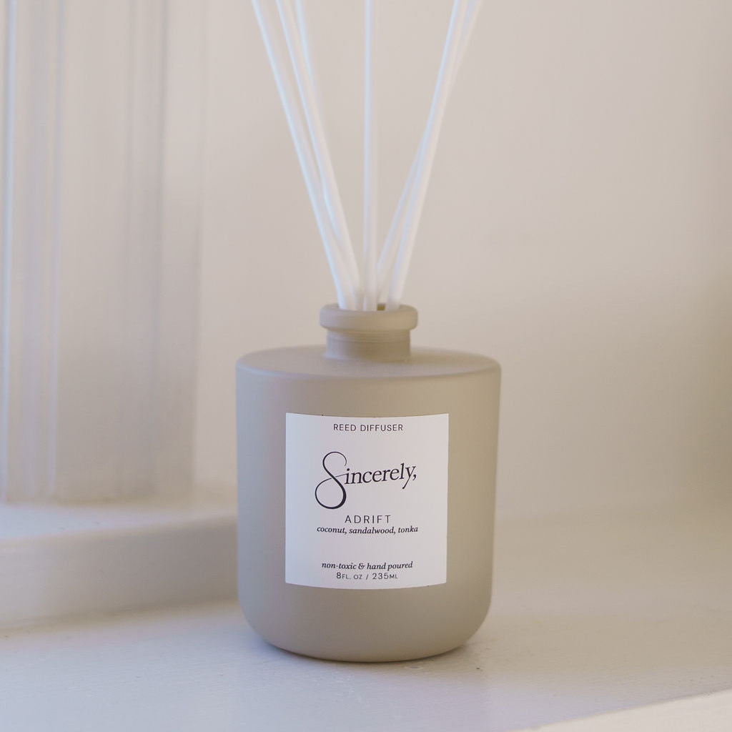Beige diffuser bottle with white sticks on a light background