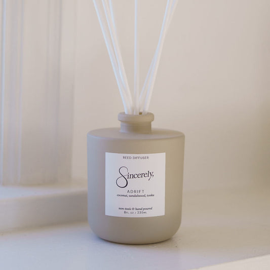 Beige diffuser bottle with white sticks on a light background