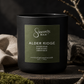 Black candle with 'Sincerely, Man' label on a wooden surface with natural elements.
