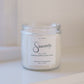 Candle jar labeled 'Sincerely' on a white surface with a light background