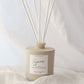 Scented diffuser with reeds on a light fabric background