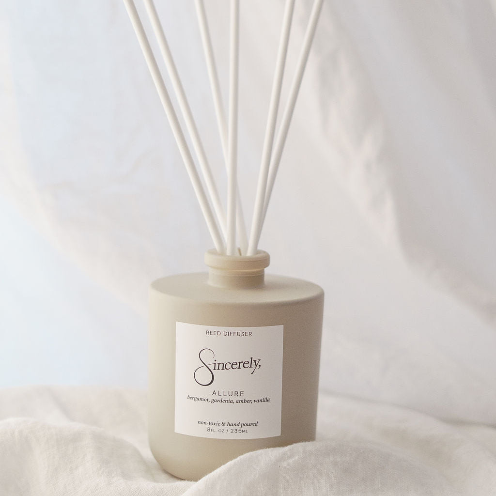 Scented diffuser with reeds on a light fabric background