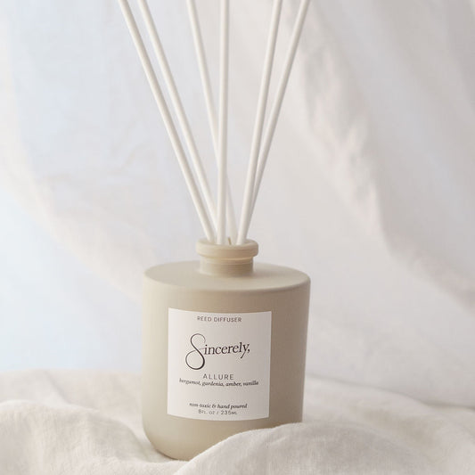 Scented diffuser with reeds on a light fabric background