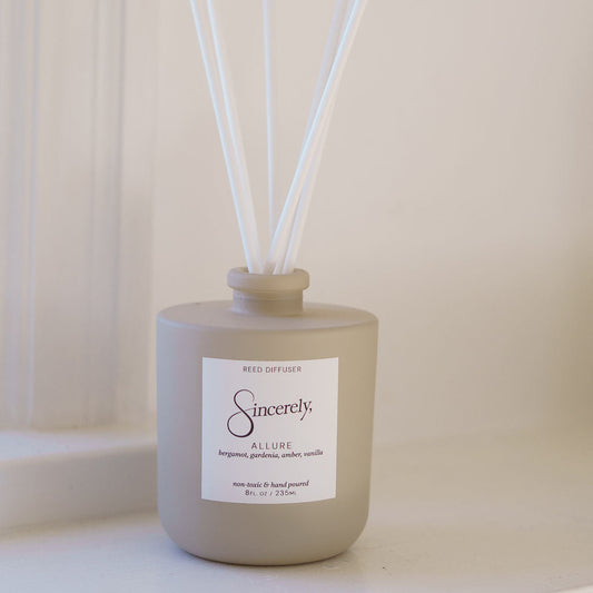 Beige diffuser bottle with white sticks on a light background