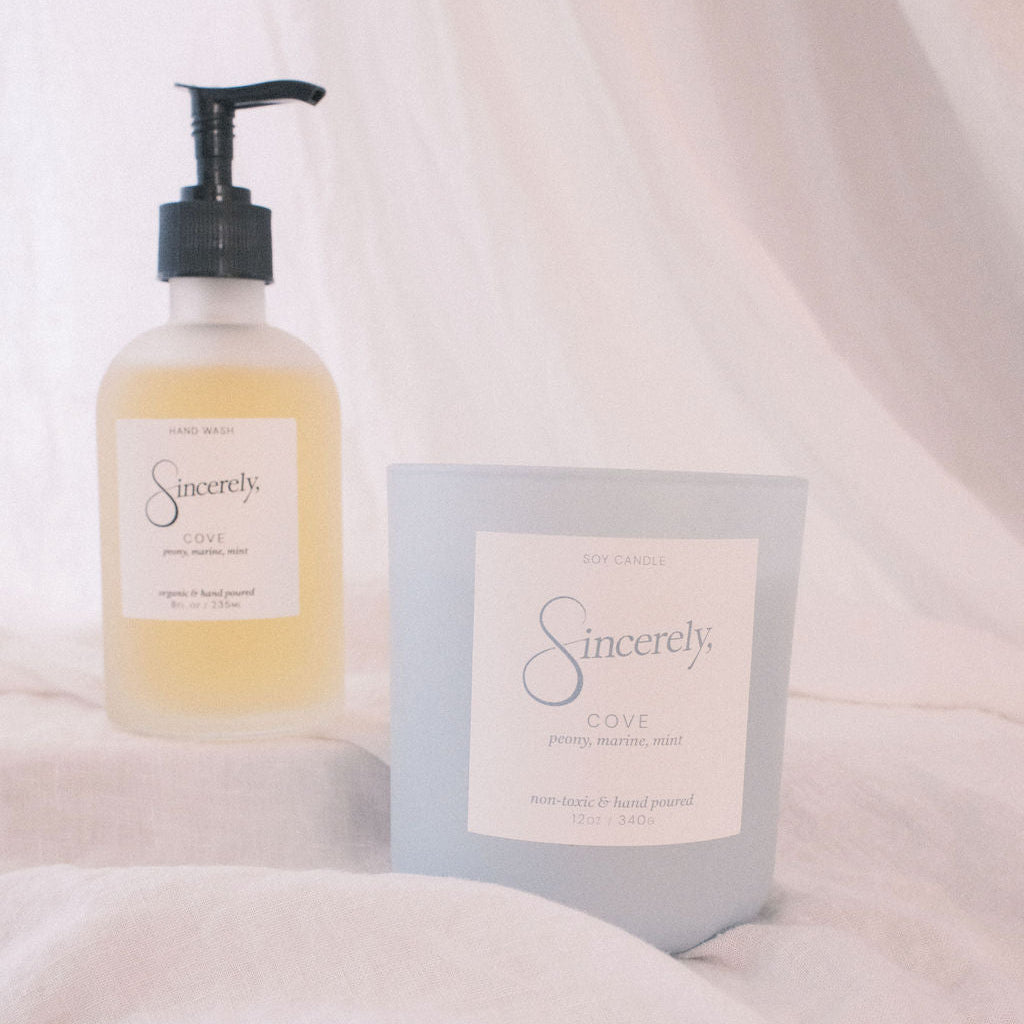 Hand soap bottle and candle with 'Sincerely' branding on a soft white background