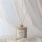 Scented diffuser with reeds on a light fabric background