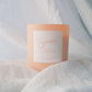 Tangerine Candle with 'Sincerely' branding on a light fabric background