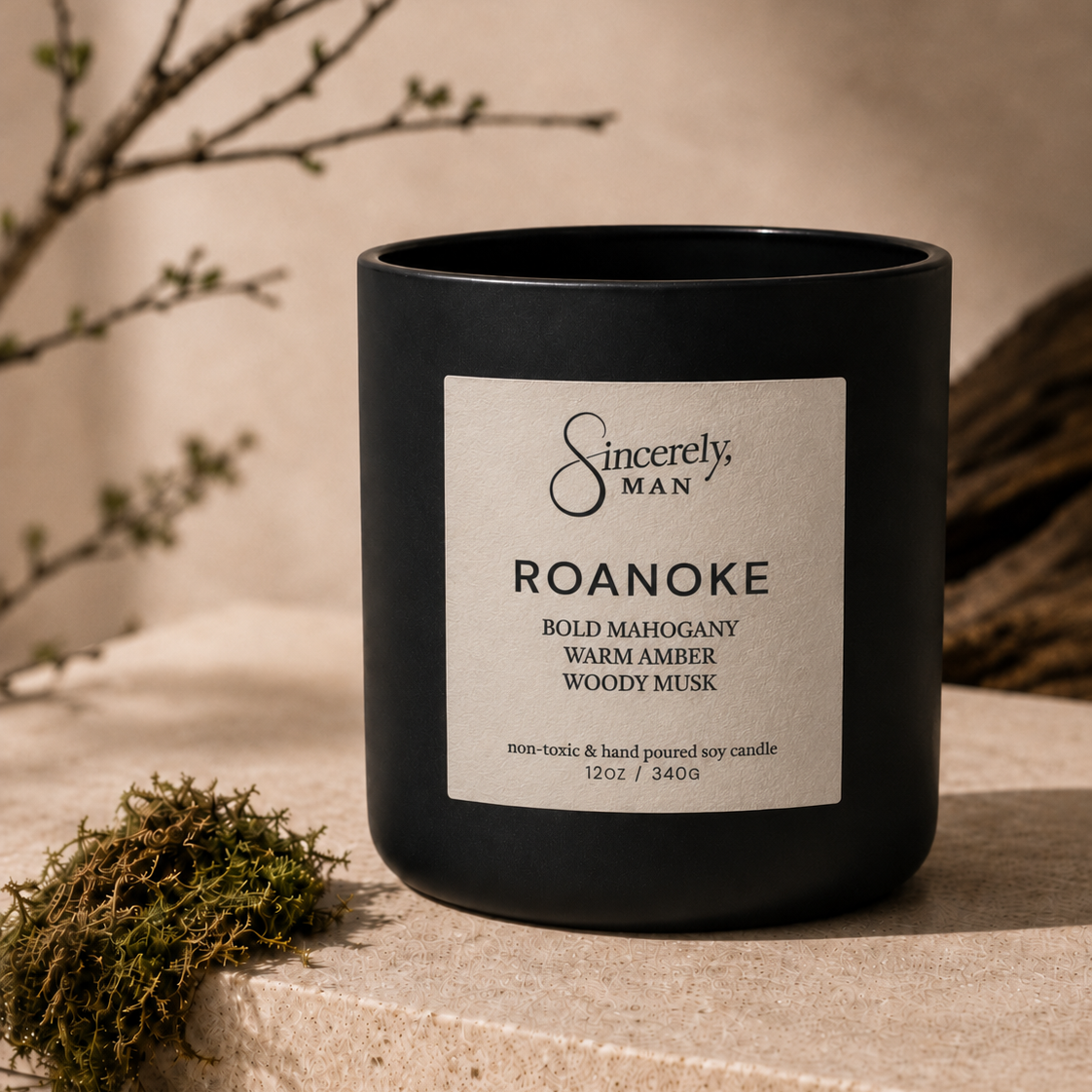 Black candle with a label on a stone surface with natural elements