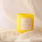 Yellow candle with a label on a white fabric background