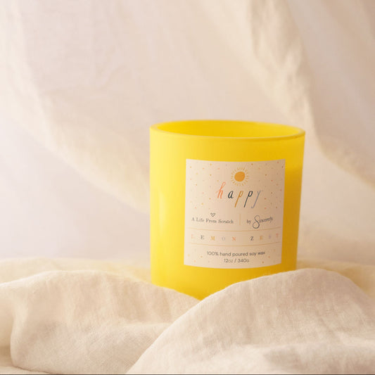 Yellow candle with a label on a white fabric background