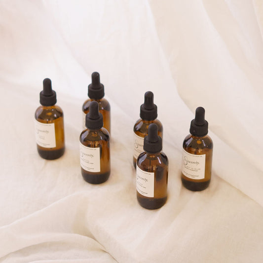 Set of glass dropper bottles with labels on a white fabric background