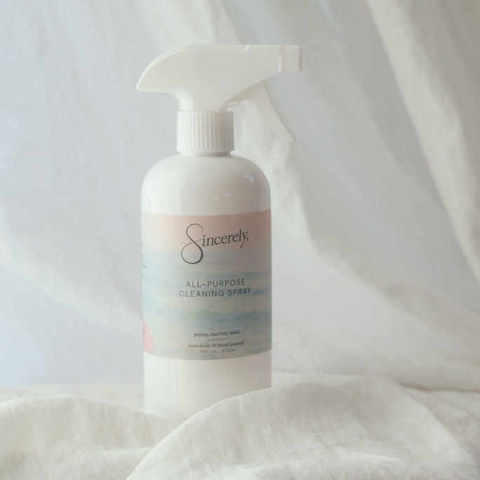 Cleaning bottle labeled 'Sincerely,' on a white fabric background