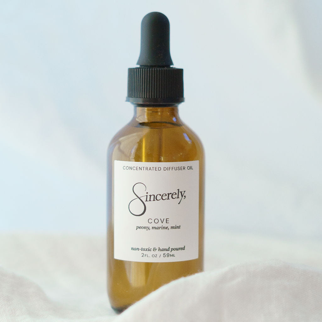 Bottle of 'Sincerely Cove' concentrated diffuser oil with a dropper on a light background