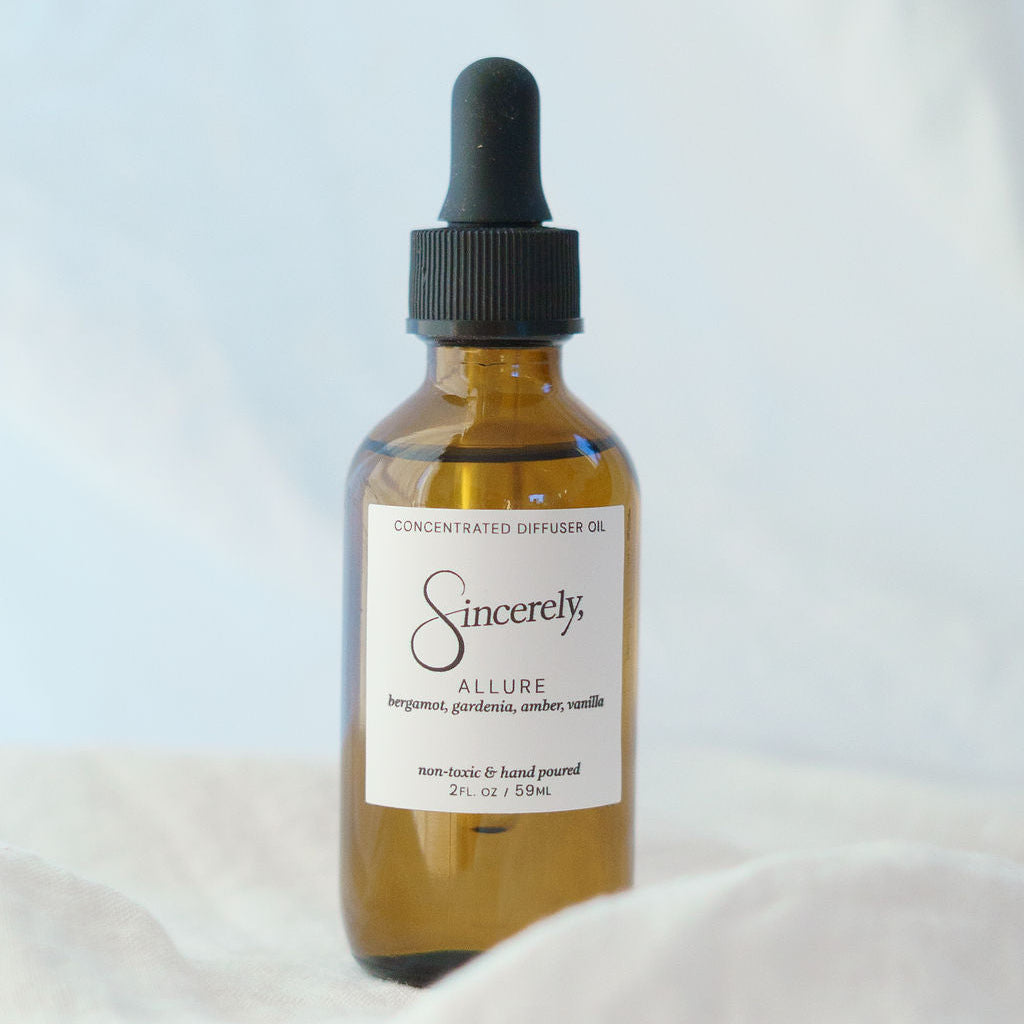 Bottle of 'Sincerely' diffuser oil on a white surface with a light gray background