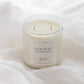 A two-wick soy candle in a clear glass jar with a white label reading 'HARVEST' and the brand 'Sincerey', set on white draped fabric.