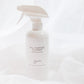 A white spray bottle of All-Purpose Cleaner with a white trigger sprayer, set against a draped white fabric background.