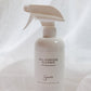A white spray bottle of All-Purpose Cleaner with a matching trigger sprayer, set against a draped white fabric background.