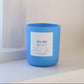 Blue candle with a label on a white surface